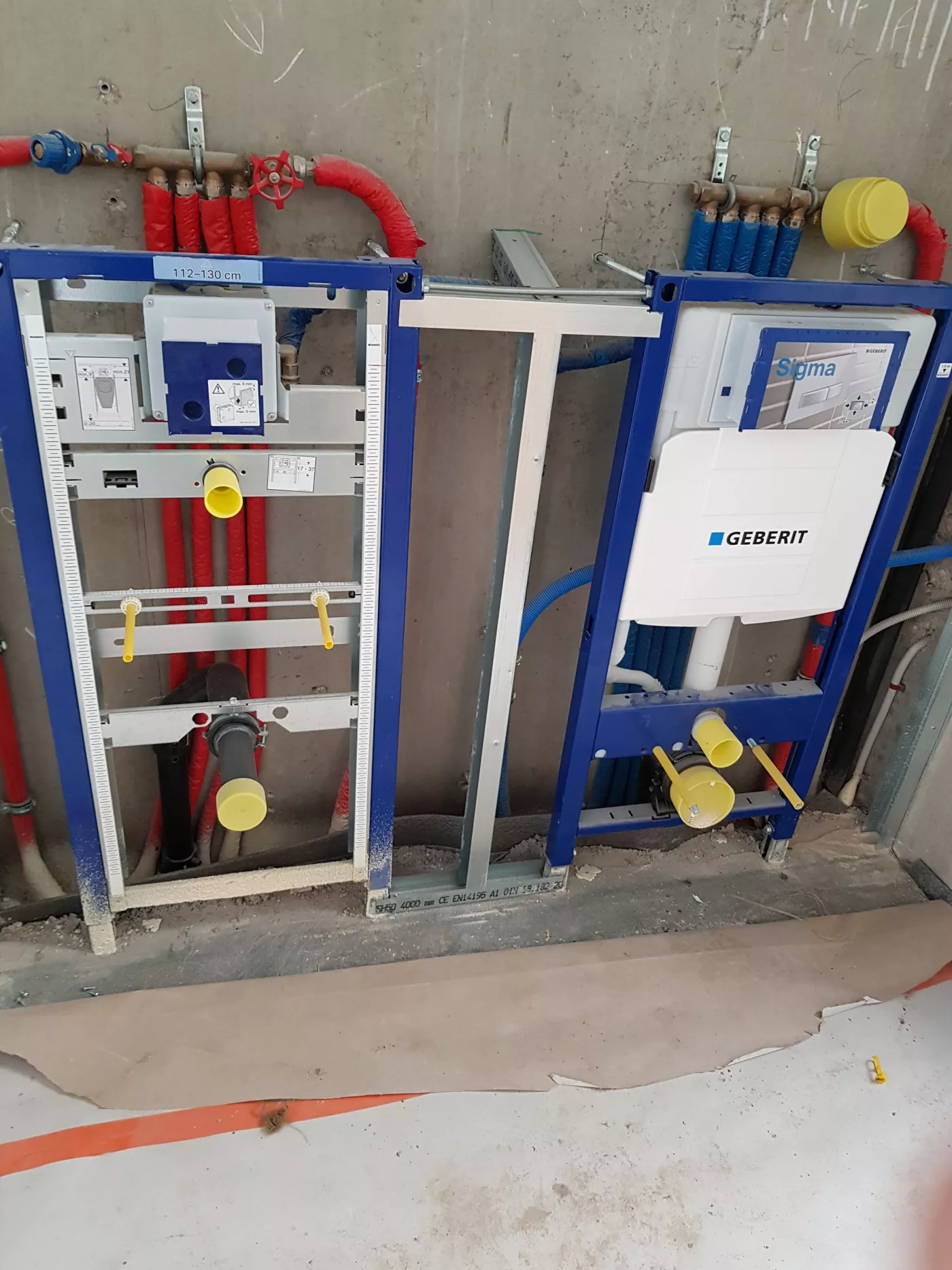 Deux bâtis-supports Geberit bleus et canalisations avant habillage
