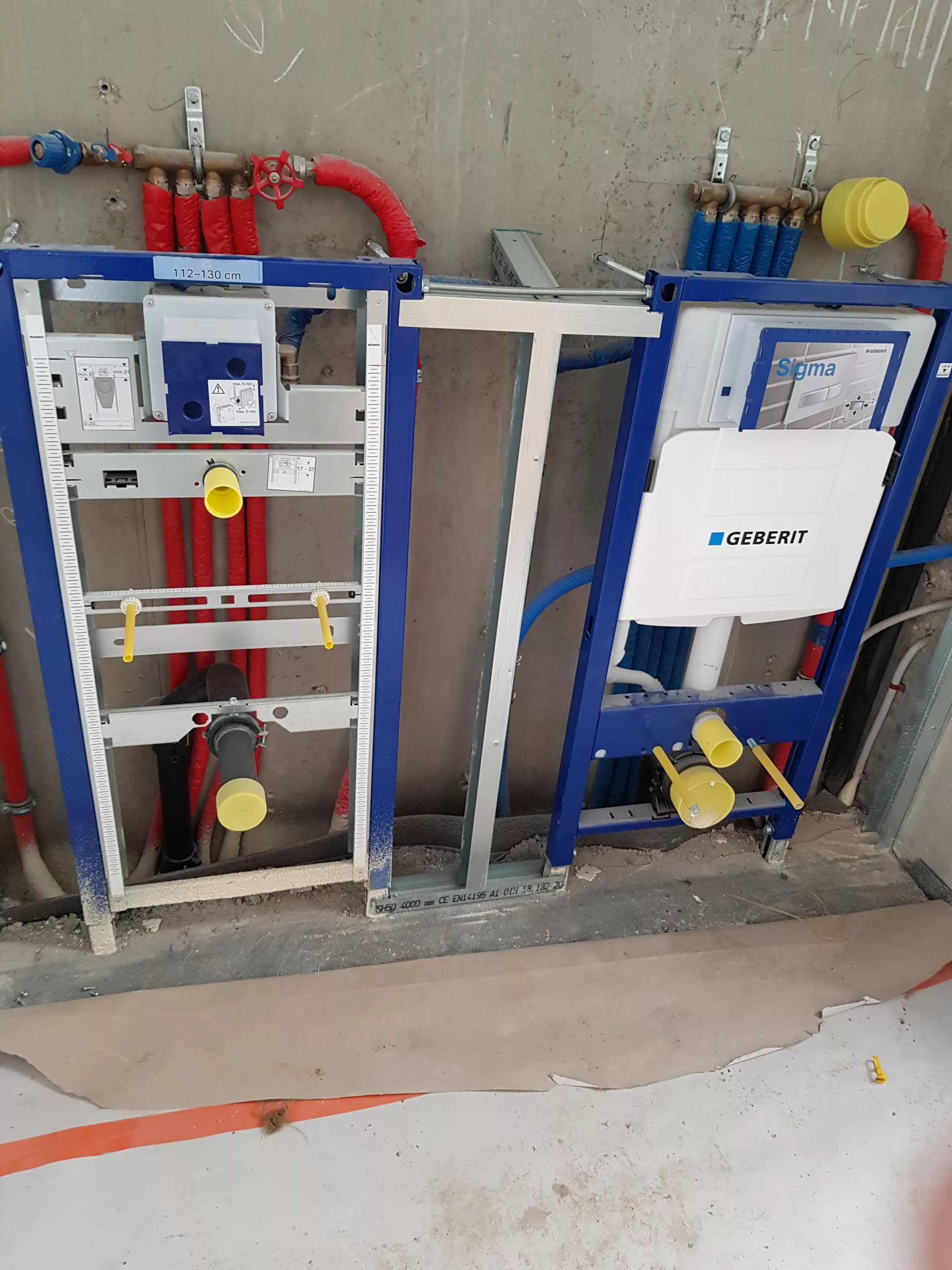 Deux bâtis-supports Geberit bleus et canalisations avant habillage